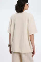 Remera oversize gris oscuro con cuello en V y mangas cortas. Presenta una estampa frontal estilo universitario con el número "09" y las inscripciones "MVD", "UY" y "PIMENTÓN ACTIVE" en tonos celestes y blancos.