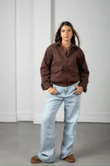 Campera corta de gamuza color marrón, con cierre frontal, cuello camisero y bolsillos frontales con solapa.