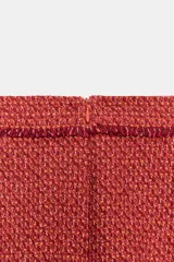 Minifalda de tiro medio confeccionada en tejido de tweed rojo, con diseño estructurado y terminaciones deshilachadas en el borde inferior. Cuenta con cierre en la espalda con cremallera oculta en costura.