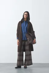 Cardigan de tejido de punto gris, con silueta larga, frente abierto, solapas clásicas y bolsillos aplicados en los laterales.