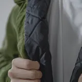 Campera color borgoña de pana con cuello camisero, cierre frontal con botones a presión y dos bolsillos de parche en el pecho. Interior acolchado con patrón de rombos.