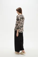 Camisa holgada de viscosa con cuello mao, mangas largas y estampado floral en tonos beige, marrón y negro, con dos bolsillos frontales con solapa.