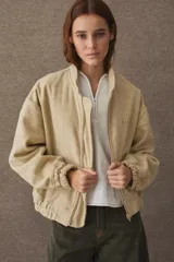 Campera bomber de paño color azul marino, con cuello de piel sintética en color marrón desmontable, cierre frontal y puños elásticos. Presenta logo bordado en el frente y bolsillos laterales.