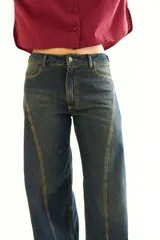 Pantalón de jean recto color gris oscuro, con efecto desgastado, recortes 360 y ajuste en cintura con presillas. Tiene tiro medio y detalles de bolsillos traseros con parches deshilachados.