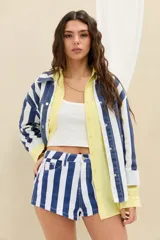 Campera de denim con diseño de rayas verticales en azul y blanco, de corte oversize, con cuello clásico, cierre frontal con botones metálicos y bolsillos appliqués en el frente.