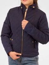 Campera capitoneada azul marino, de manga larga, con diseño matelassé romboidal, cuello alto con presilla y cierre frontal metálico dorado. Cuenta con bolsillos frontales con broches y ajuste elástico en los laterales.