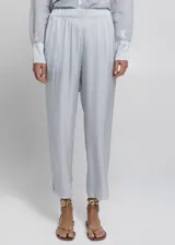 Pantalón cropped de tiro alto con cintura elástica ajustable mediante lazo. El tejido es ligero y presenta un acabado ligeramente satinado, en un tono celeste o gris muy claro.