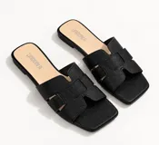 Sandalias planas de diseño cruzado tipo H en la capellada, con punta cuadrada y suela baja, de color negro.