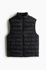 Chaleco negro acolchado con cuello alto y cierre frontal. Diseño sin mangas con bolsillos laterales con cierre y bolsillos interiores abiertos.