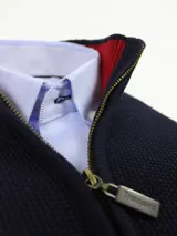 Campera gris de hilo con cierre frontal y cuello alto, tejido de punto panal.