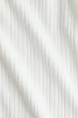 Remera de manga larga de punto pointelle acanalado, color blanco, con escote en U y detalles de ondas en los puños y el bajo.