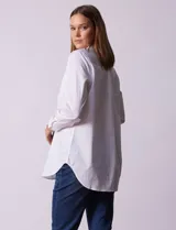 Camisa blanca de tencel, marca Grand & Greene, con cuello a la base, escote en V y abertura central con botones. Manga larga con puño y botón.