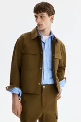 Sobrecamisa boxy de algodón, color verde militar, con cuello inglés, tapeta con botones a presión y bolsillos superiores con solapa.