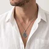 Collar con cadena de eslabones y dije circular de acero empavonado con la imagen de San Cristóbal en relieve.