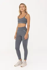 Top deportivo gris con breteles finos regulables y contorno inferior blanco.