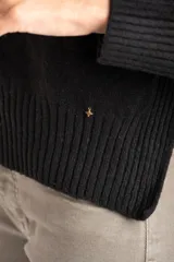 Sweater de punto color negro confeccionado en mezcla de lana lambswool y nylon. Presenta cuello alto tipo polera, manga larga y terminaciones acanaladas en puños y bajo.