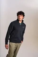 Buzo de cuello alto con cierre frontal parcial, manga larga y puños acanalados. Presenta un diseño liso en color negro con el logo de la marca bordado en el pecho.