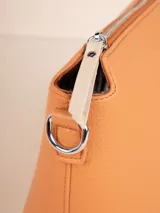 Bandolera color beige de cuero sintético texturizado, con correa desmontable y regulable. Tiene un compartimento principal con cierre y tres bolsillos internos adicionales.