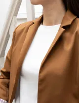 Blazer crop color marrón, marca Dictionary. Cuello con solapa, manga larga y forro interno estampado a rayas.