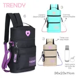 Mochila matera color beige con detalles en lila y negro. Cuenta con un bolsillo frontal extra, correa y llavero desmontable, y tiras con tela mesh. Tiene un parche de corazón lila en la parte superior y la palabra "TRENDY" estampada en lila en el bolsillo frontal.