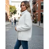 Campera de corderito color blanco, con cuello alto, cierre frontal completo y un bolsillo en el pecho con cierre.