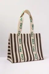 Bolso tote de lona a rayas verticales marrones y blancas con asas de mano y estampado "Ciao" en las asas.