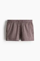Short de baño de sirsaca con diseño a rayas verticales. Presenta cintura elástica con cordón de ajuste, bolsillos laterales y un bolsillo trasero abierto. Incluye suspensor interior de malla.