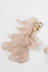 Aros colgantes con diseño floral compuesto por múltiples pétalos de tela en tono nude y base metálica dorada con textura irregular.