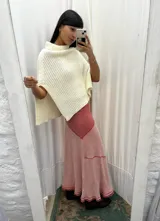 Falda larga de punto de algodón, con diseño evase en tonos rojos y rosados, con textura acanalada y dobladillo deshilachado.