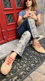 Pantalón de jean con paneles laterales de cuero con estampado de reptil. Presenta un diseño de corte recto y combinación de materiales.