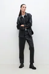 Sobrecamisa negra de cuero sintético con cuello camisero y tachas plateadas.