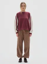 Buzo de felpa suave color azul marino con interior de frisa, calce oversized y detalles laterales a contratono en color beige en las mangas. Tiene un bordado del logo de la marca en el pecho y la palabra "PASTICHE" bordada en la espalda.