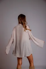 Camisa rosada con detalles de broderie en la parte delantera y mangas anchas.