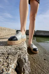 Alpargatas color blanco hueso con puntera negra, hechas artesanalmente en cuero ovino de alta calidad.