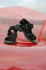 Sandalias negras de cuero y gamuza con tiras anchas, cierres de velcro y suela dentada de goma.