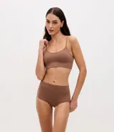 Soutien tipo top de color negro, confeccionado en tejido seamless texturizado con tirantes finos ajustables. Cuenta con copas desmontables y diseño sin costuras.