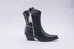 Botas estilo texanas de caña media, confeccionadas en cuero con estampado animal print tipo vaca en blanco y negro. Presentan un diseño de punta fina y taco cuadrado.