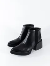 Botas cortas negras de cuero con cierre lateral y elástico en los laterales. Taco cuadrado y plataforma.