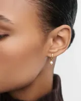 Aros pequeños dorados con colgante de perla cultivada de agua dulce.