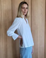 Blusa de algodón con cuello mao y volados, mangas largas con puños elásticos y corte holgado.