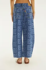 Pantalón de jean estilo barrel, color azul, con estampado geométrico de monogramas. Presenta tiro alto y corte ancho y curvo en las piernas.