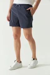 Short de baño liso de corte clásico, con cintura elástica ajustable mediante cordón. Cuenta con dos bolsillos laterales y uno trasero, confeccionado en tejido ligero de secado rápido con logo bordado.