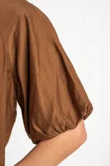 Blusa color marrón con mangas globo cortas y escote redondo.