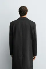 Abrigo regular fit de color negro, confeccionado con mezcla de lana y cashmere. Presenta cuello con solapas de muesca, manga larga, bolsillos de vivo en la cadera, abertura central en la espalda y cierre frontal de botonadura con tres botones.