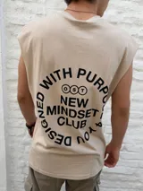 Musculosa de color beige con cuello redondo y corte holgado. Presenta un estampado minimalista en negro en el lateral del pecho con el nombre de la marca Osten Studio y coordenadas geográficas.