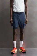 Shorts de entrenamiento azul marino con calza interior negra. Cintura elástica ajustable con cordón, bolsillos laterales con cierre y aberturas laterales en el bajo.