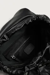 Mochila de piel negra de la colección especial Aaron Levine x Zara, con compartimento principal con solapa y hebilla, bolsillos exteriores en los laterales y asas ajustables.