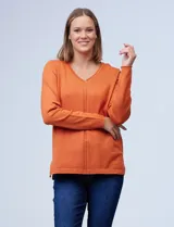 Buzo de tejido fino color naranja, marca Tint & Shadow, con escote en V y pespunte central.
