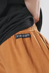 Bermuda de corte regular color tabaco, confeccionada en tejido de algodón con textura tipo lino. Presenta cintura elástica con cordón ajustable con detalle de marca bordada y dos bolsillos delanteros.