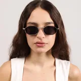 Lentes de sol con marco metálico dorado de forma hexagonal y cristales oscuros. Presentan un diseño con textura estriada en el borde del marco y detalle de marca en las patillas.